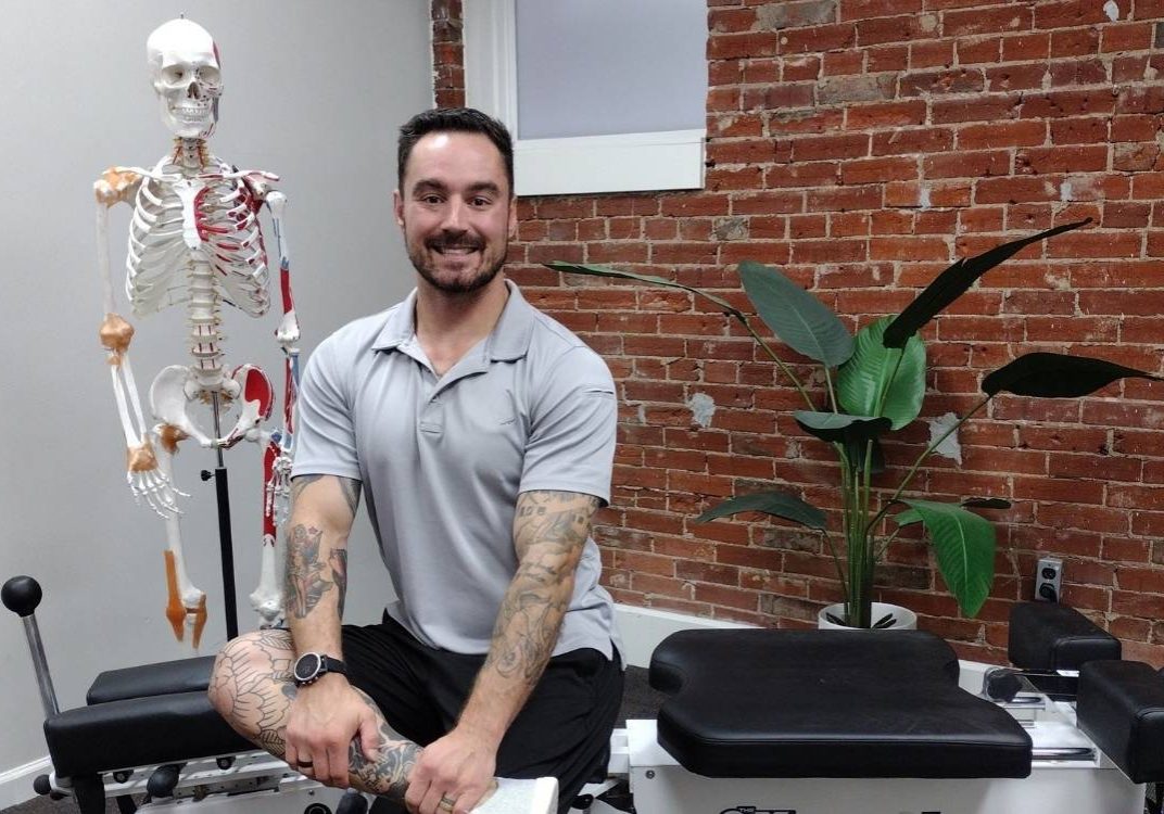 Photo of Dr Kevin Pisle, a Lima, Ohio chiropractor, sitting on his adjustment table.
