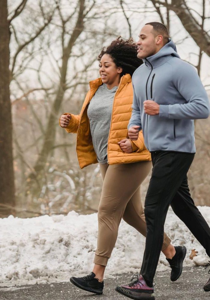 Photo of a man and woman running together outside